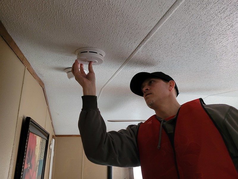 volunteer installing smoke alarm