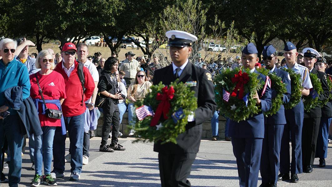 service members carrying wreaths