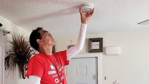 Red Cross volunteer Allan Ramos installs a smoke alarm in a Fort Worth home. 