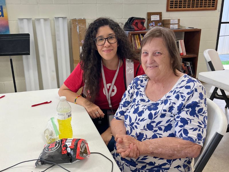 red crosser and woman sitting at table