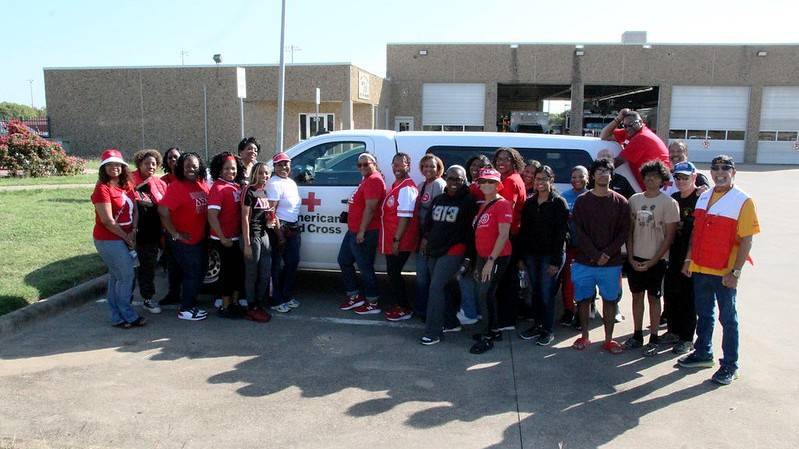 Red Crossers, the DeSoto Fire Department and community members group pic in front of a red cross vehicle at the Sound the Alarm event.