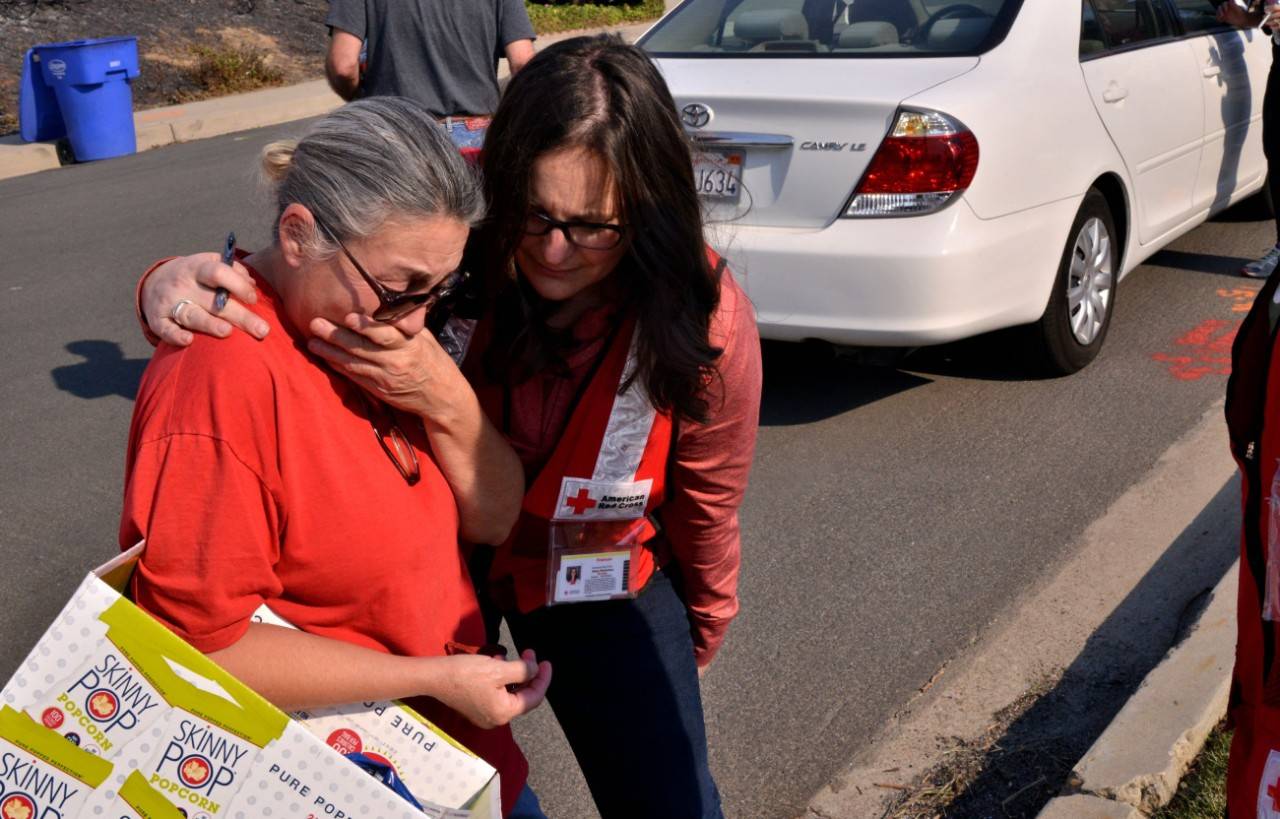 December 14, 2017. Ventura, California.
This is the first time Nancy and Bill Golden had been allowed to return to their home since the Thomas fire tore through the Skyline neighborhood. Nancy had just accepted a box of snacks from the Red Cross ERV when she turned around and burst into tears.  I just saw my view,  she said of the smoky horizon. The couple donned protective gear before stepping into the charred remains of their former household to see if anything meaningful survived.
Photo by Dermot Tatlow/American Red Cross