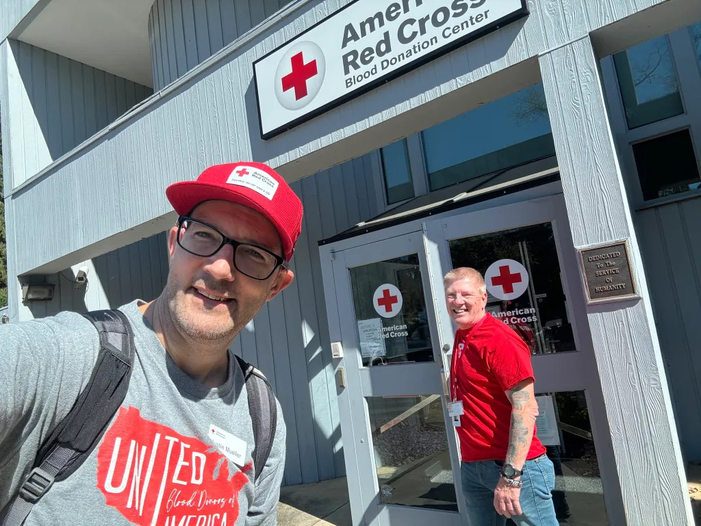 justin with red crosser in front of blood donation center