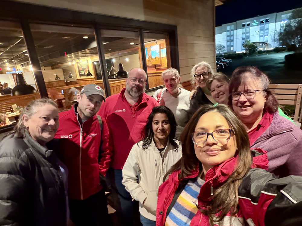 Andrew Rosenberg with a group of Red Crossers at the front of a restaurant.
