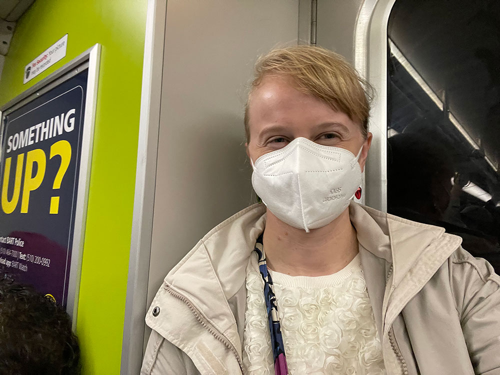 Veronica wearing a mask while riding the BART train.