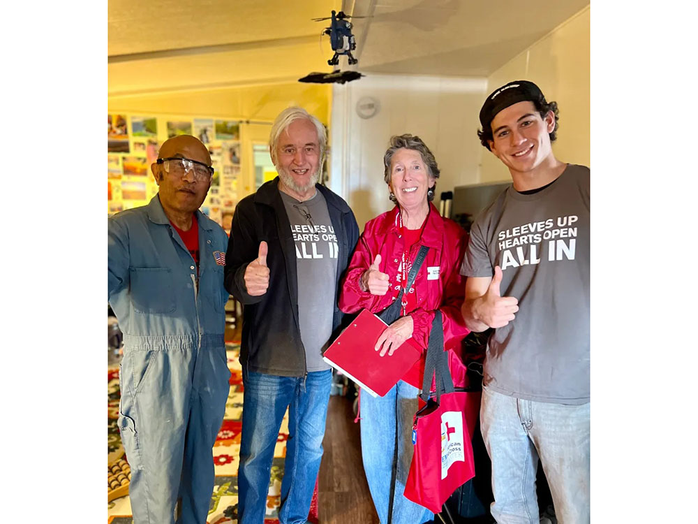 Resident Paul Ballesteros, Red Cross volunteers John, Kathleen Savage and Brayden all giving a thumbs up.