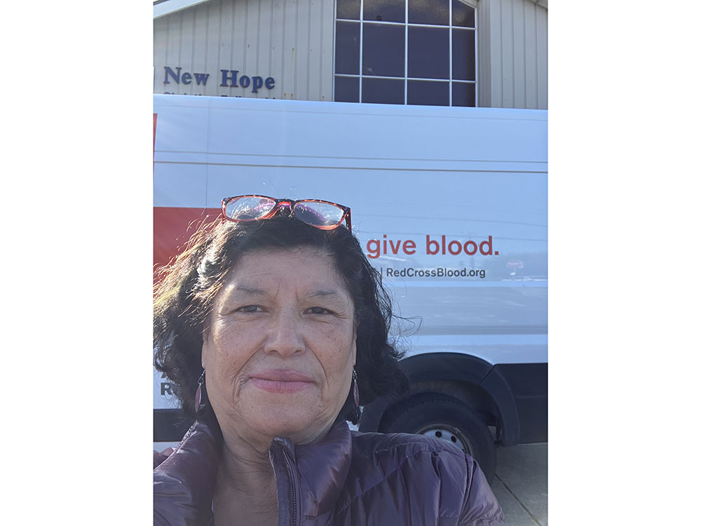 Catalina Ramirez-Vaughn selfie with glasses on head standing in front of Red Cross vehicle