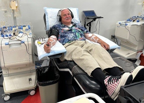 Craig Wilson laying on a bed, donating blood.