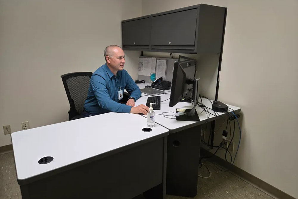 Dr. Justin Nast sitting at a desk and working on a computer.