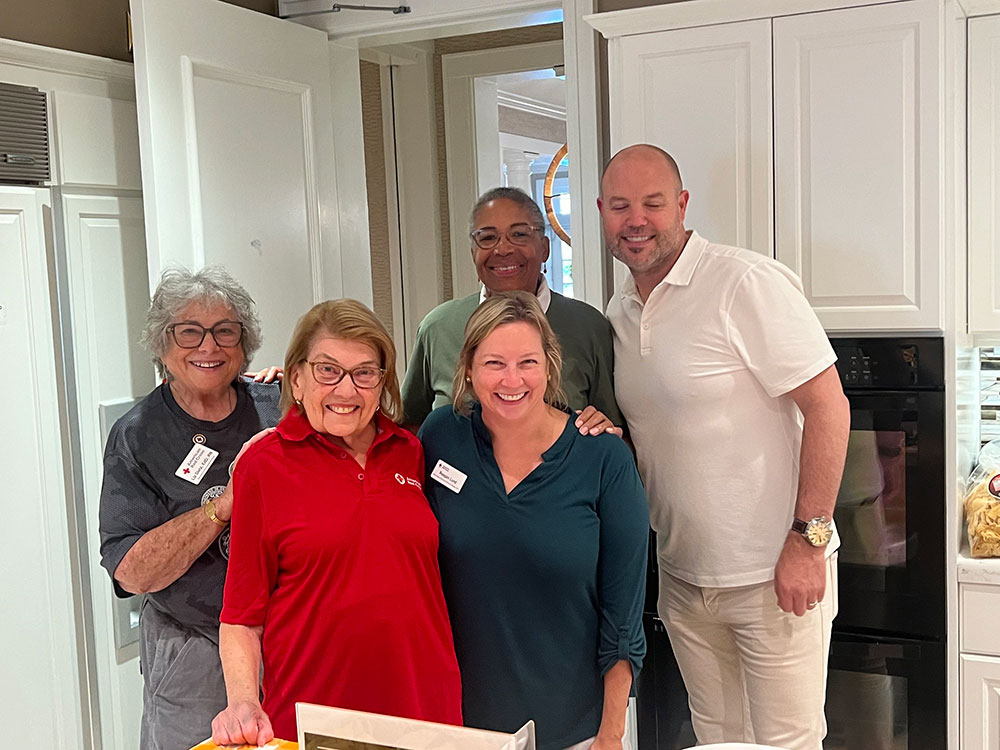 Five volunteers pose for a picture in the Fisher House kitchen.