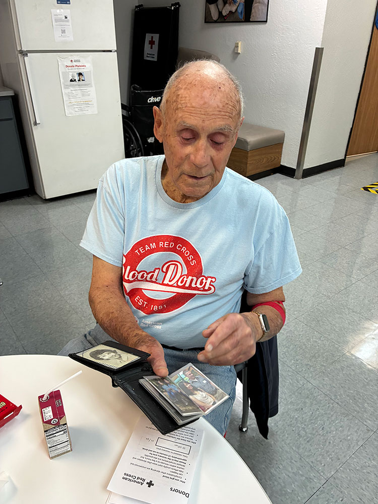 Fred Sullivan, sitting at a table, sharing memories and photos of his family.