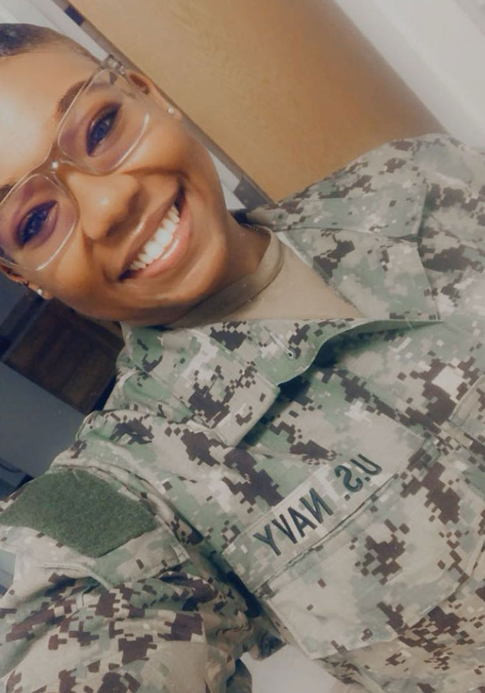 a selfie of a smiling person in military camo clothing.