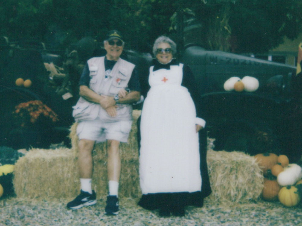 Colonel (Retired) Larry Dietz, US Army and Dr. Liz Dietz, EdD, RN sitting on a hay bale at the Moffett Field Veterans Fair.