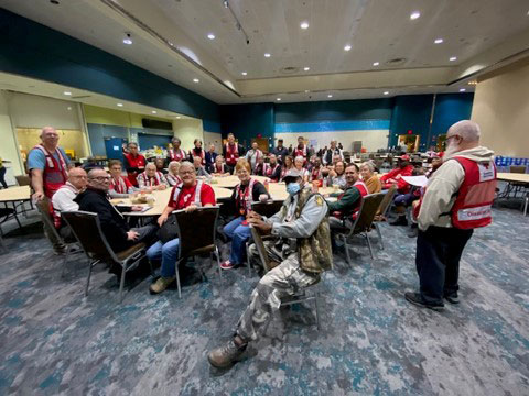 room full of red cross volunteers sitting at a conference table.