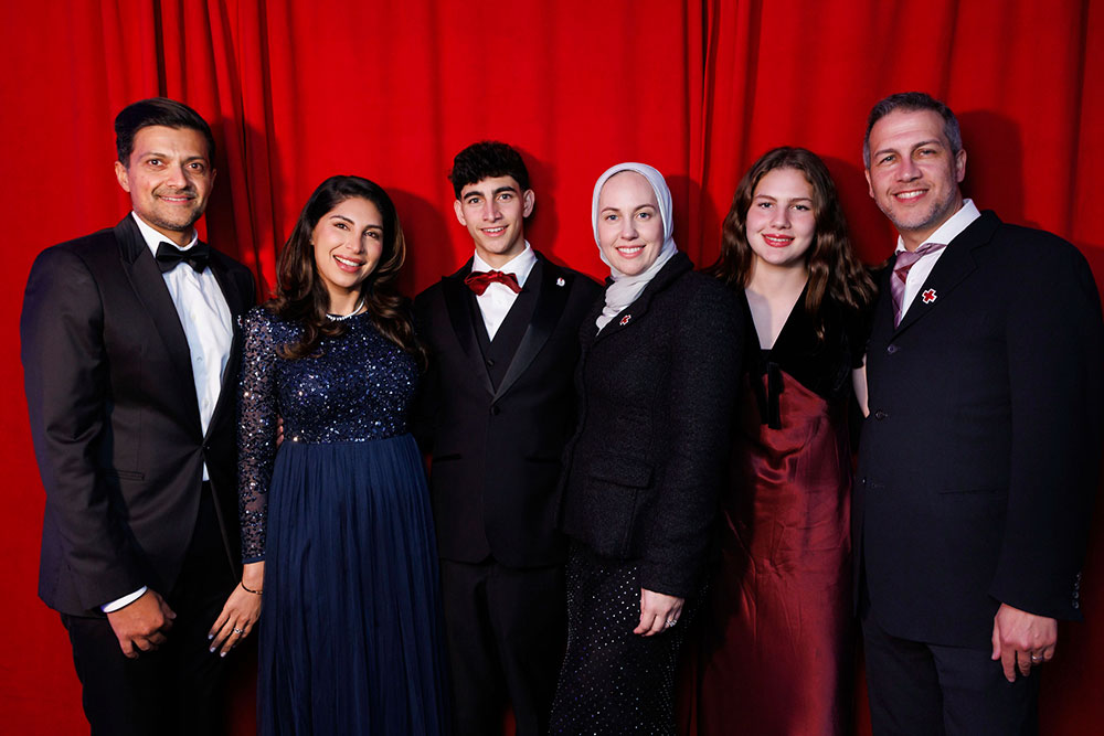 Malik with his family and loved ones, all wearing cocktail event attire, at the 2026 Red Cross Gala.