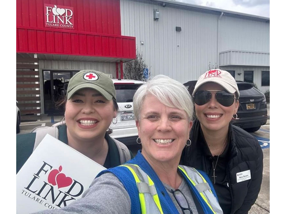 Margarita Moreno and two other people stand in front of a Food Link building.