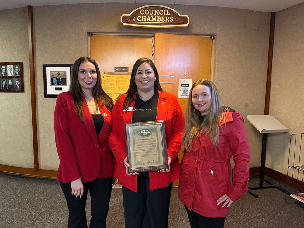 Margarita Moreno, standing next to two other people, holds a framed award.
