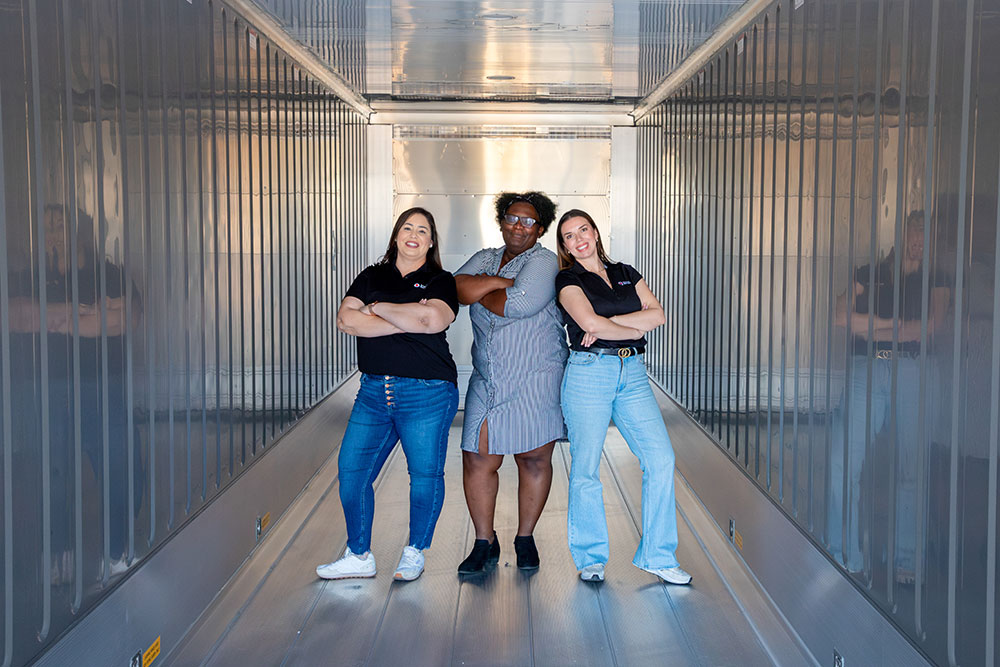 Margarita Moreno and two other Red Cross volunteers pose with arms crossed in an empty storage container.