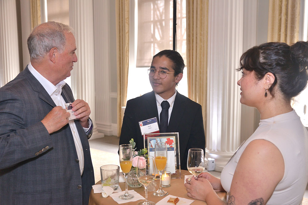 Razi Aftab and two other people, in dress clothing, at a Red Cross event.