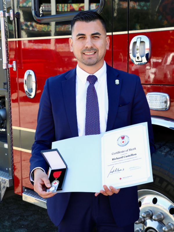 richard castellon holding certificate of merit from red cross.
