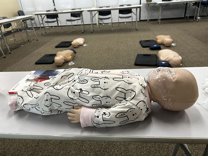 a baby CPR manikin lying on a table.