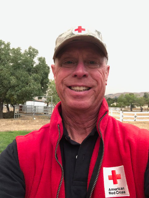 Tom Tanner in Red Cross jacket smiling for camera