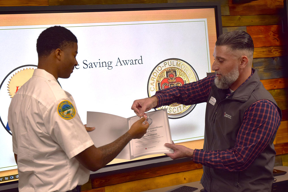 Vincent Valenzuela presenting the Certificate of Extraordinary Personal Action to Vincent Hayes.