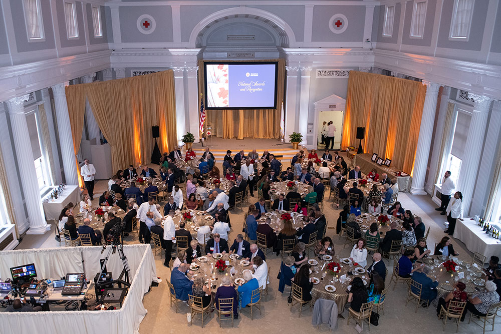 A bird's-eye view of dinner hall full of tables and guests.