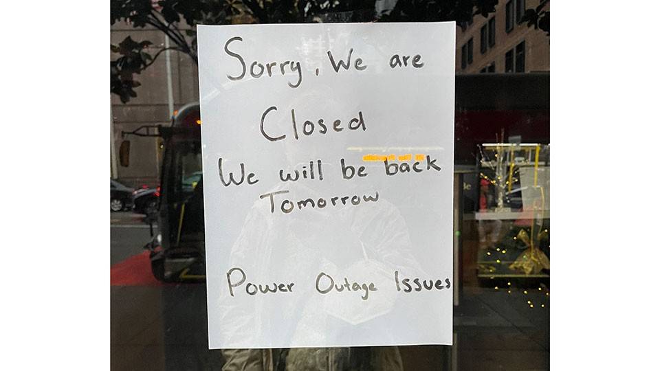 Note on Business window in downtown San Francisco about being closed due to the power outage.