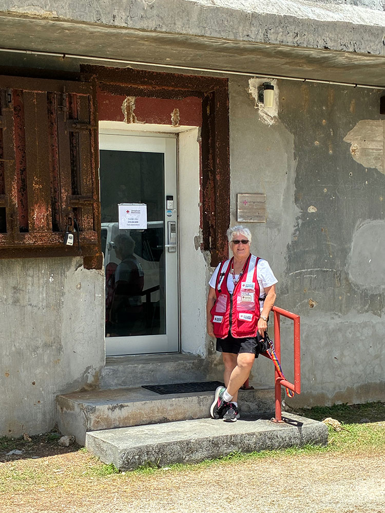 Volunteer Gale Carli standing next to the front door of the Red Cross office in Saipan.