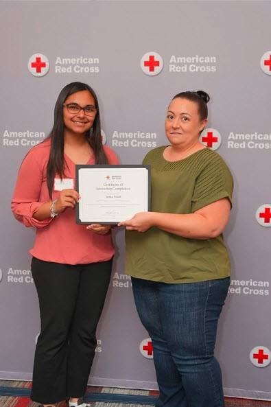 Red Cross intern Hrithika Trivedi receiving her internship completion certificate.
