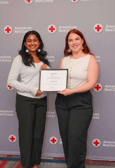 Red Cross intern Neha Varughese receiving her internship completion certificate.