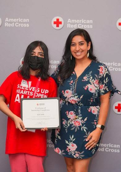 Red Cross intern Quinn Aftab receiving her internship completion certificate.