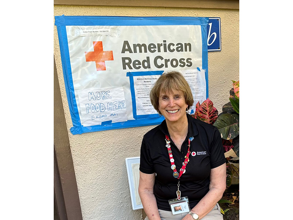Ann Kuchins wearing Red Cross shirt smiling for camera