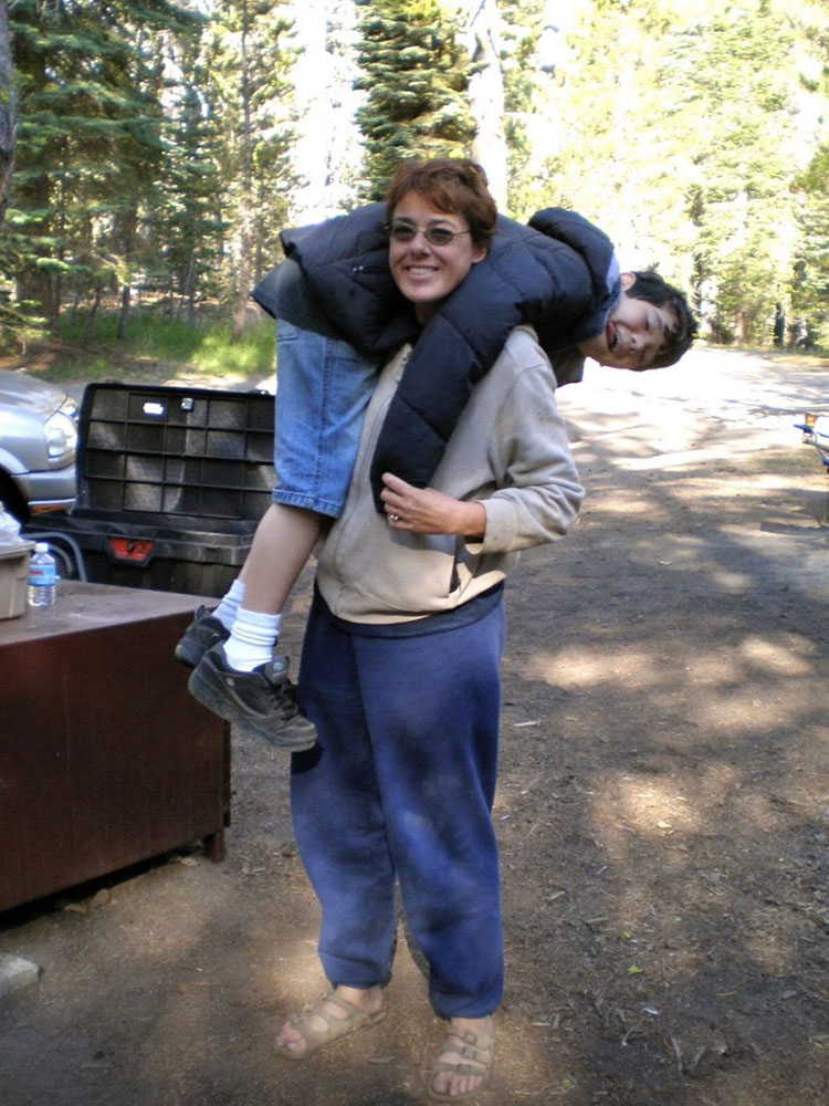 Melody Yamaguchi holding her son over her shoulders and goofing off on a camping trip.