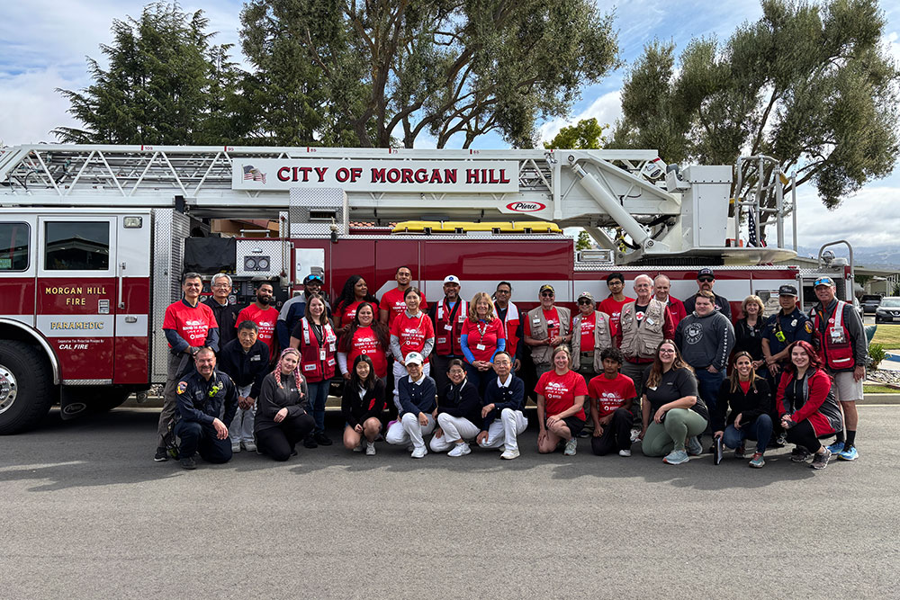Red Cross volunteers group photo in front of a fire engine.