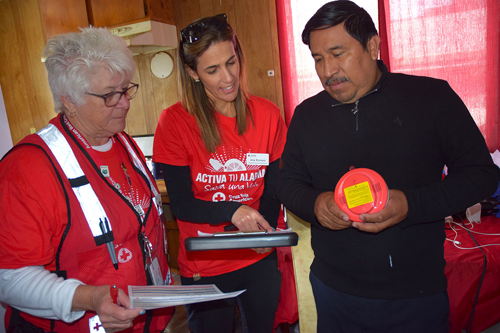 Red Cross volunteers showing a resident fire escape plans.