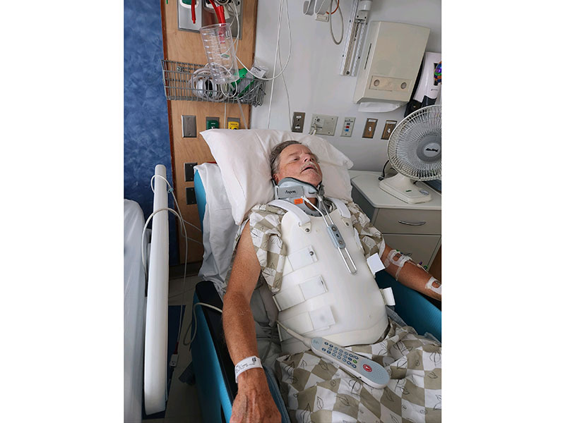 Mark Munson with body brace in hospital bed