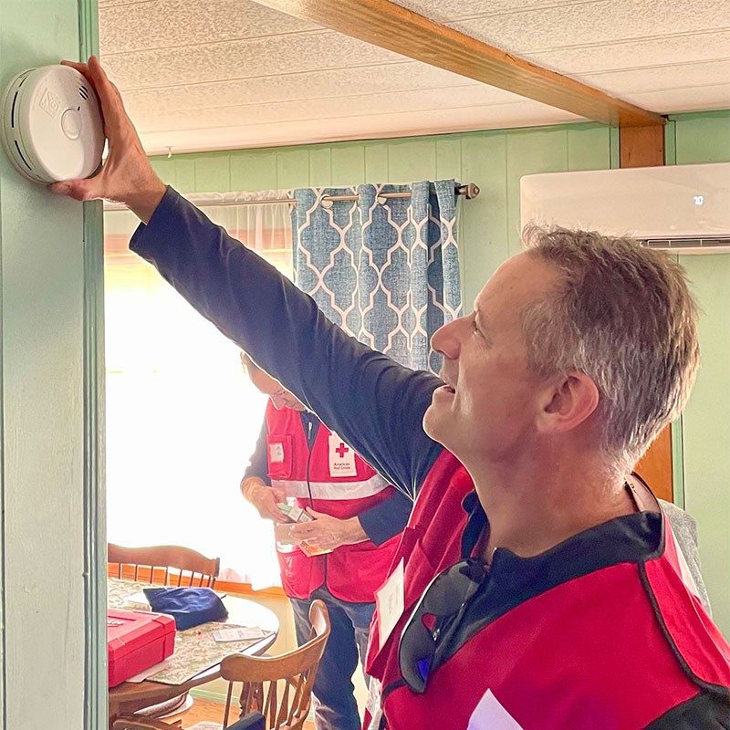 Red Cross volunteer installing smoke alarm