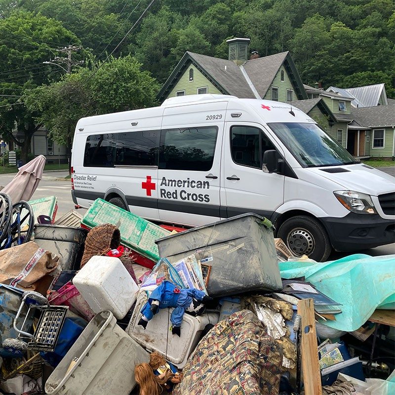 Red Cross van next to damaged property