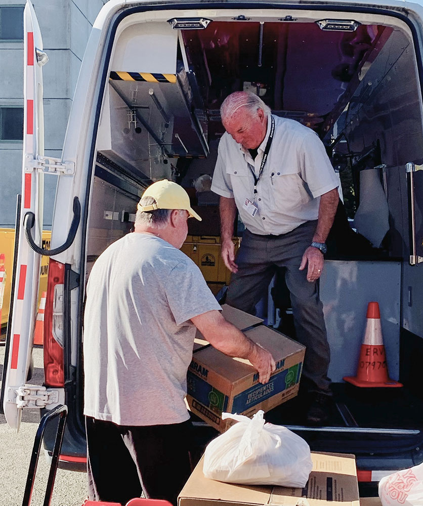 Red Cross volunteers loading supplies into a Red Cross vehicle.