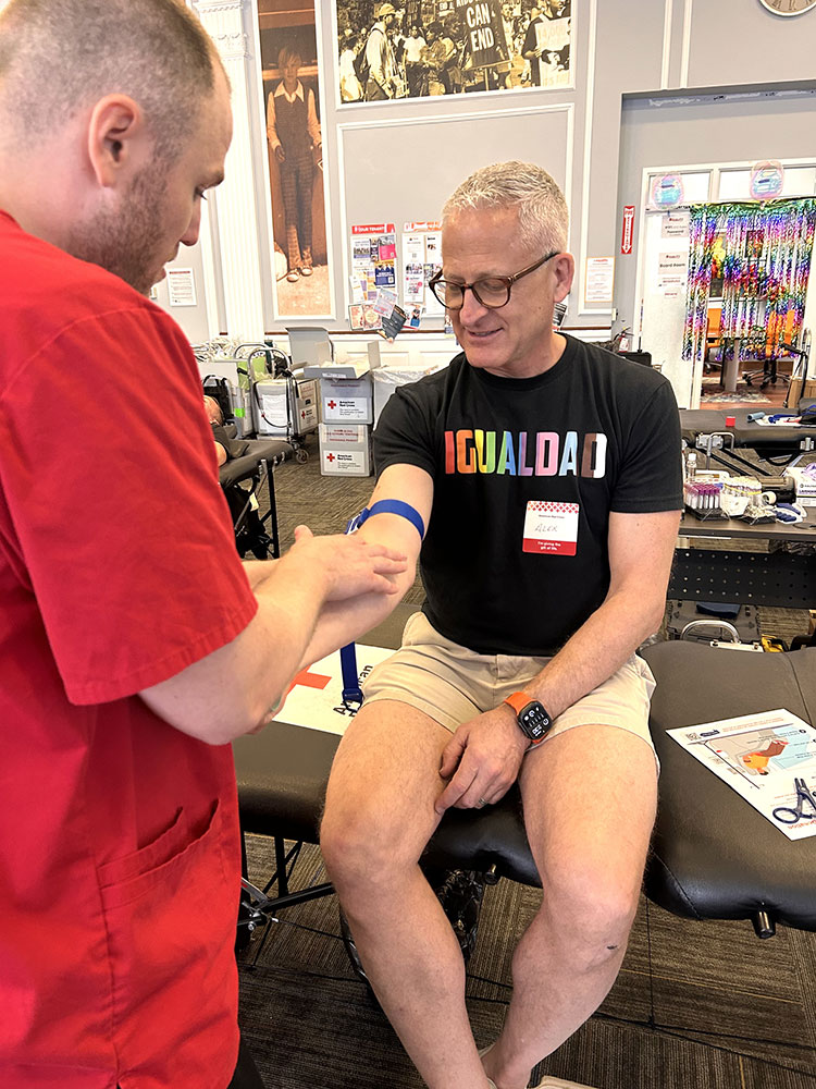A Red Cross nurse preparing Alex Beal's arm for blood donation.