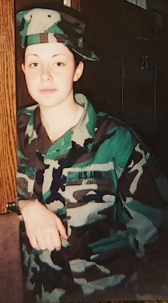 Ashley St. Louis wearing Army Combat Uniform with hat on sideways.
