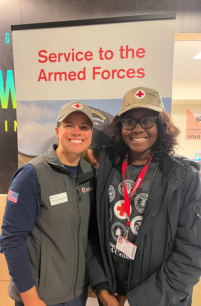 Red Cross volunteer Chinenye Angela Okoli standing next to another volunteer.