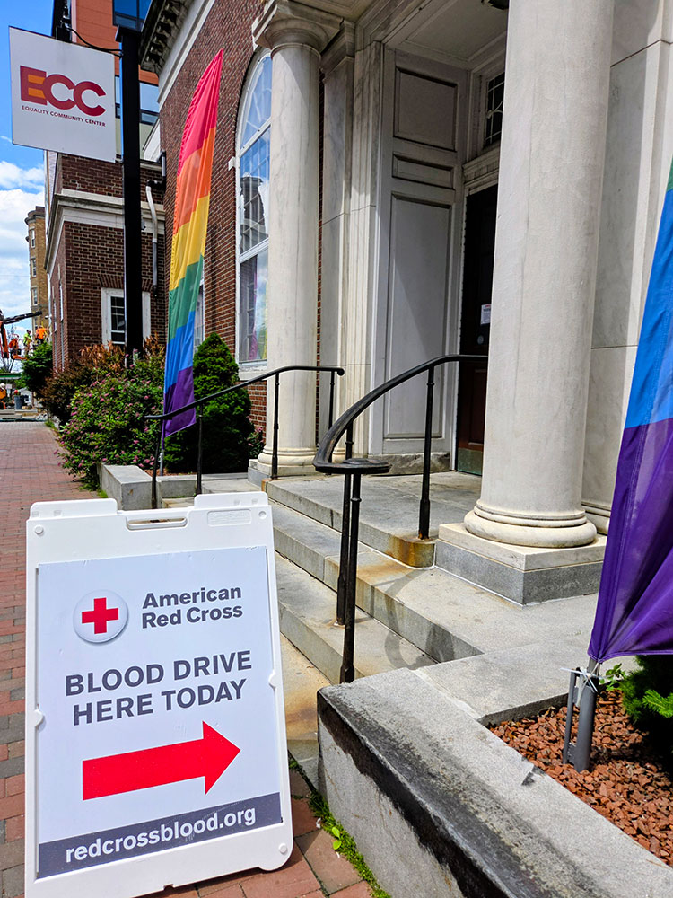 American Red Cross blood drive sign on a sidewalk.