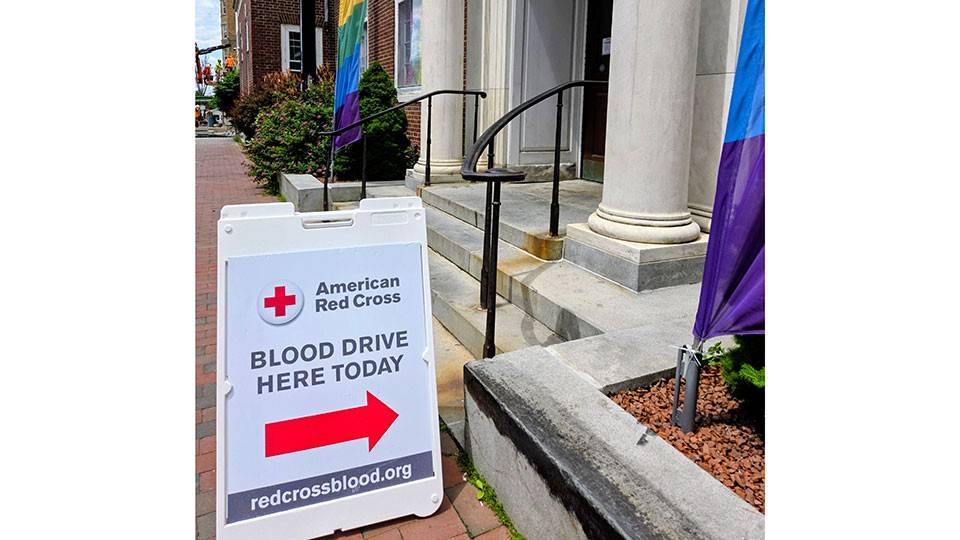 American Red Cross blood drive sign on a sidewalk.