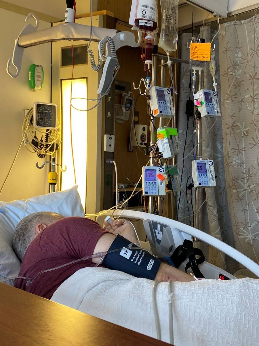 Ed Moreshead in a hospital bed recieving a blood transfusion 