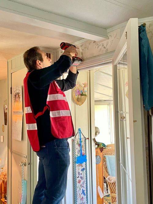 image of man installing smoke alarm 