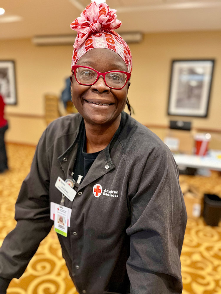 Ivy Grey Robinson wearing head wrap, glasses and Red Cross jacket.