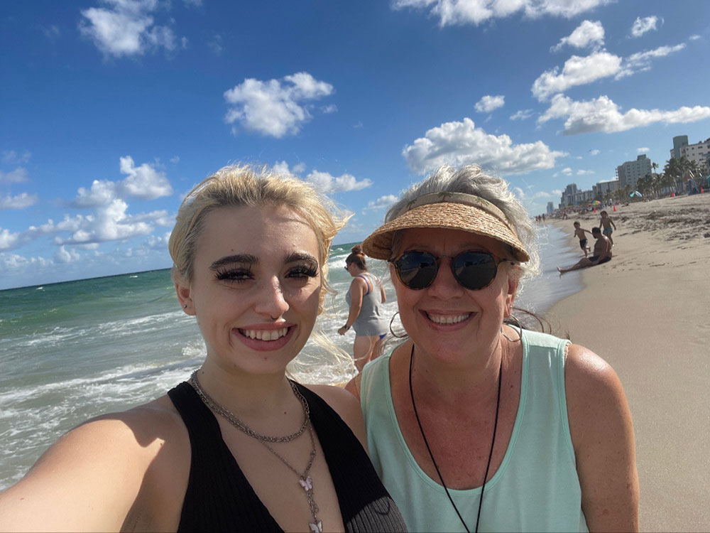 Jade and Marcia Howard take a selfie with each other at a beach.
